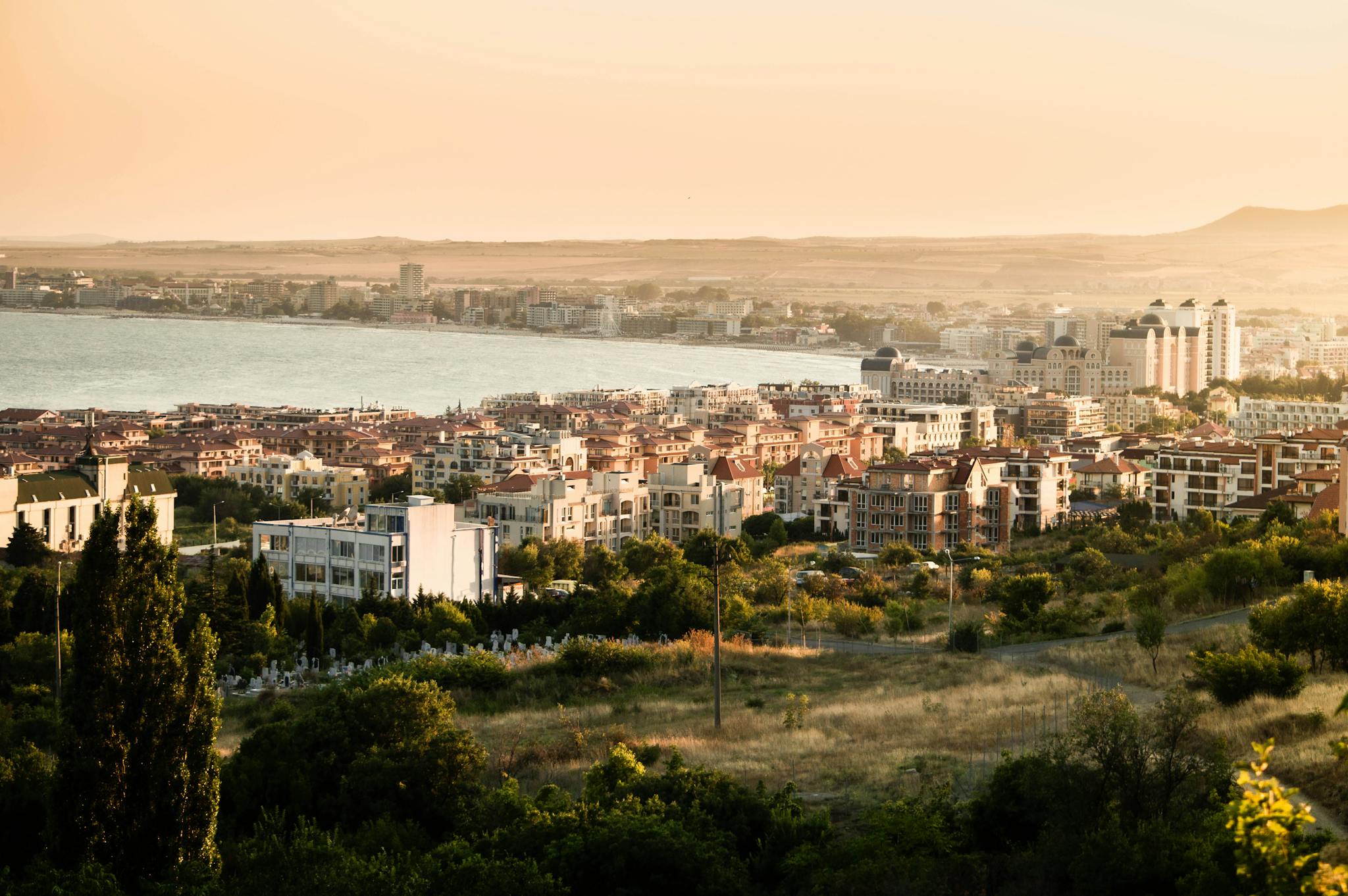 A City with White and Brown Buildings Near a Mountain and Body of Water